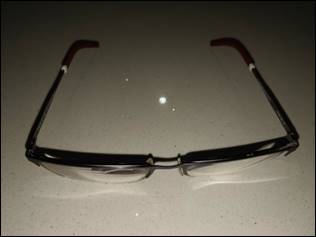 Description: A pair of glasses on a table

Description automatically generated